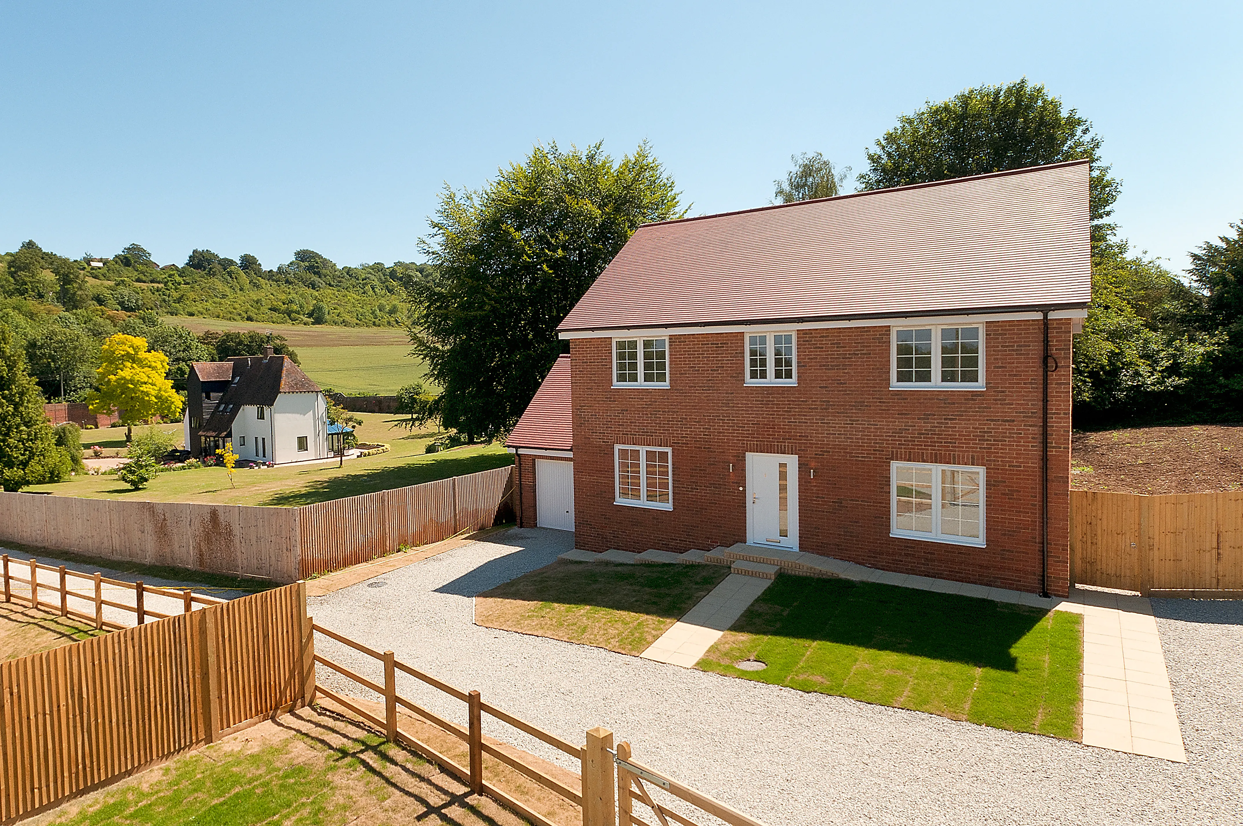 a red brick house with a fence surrounding it